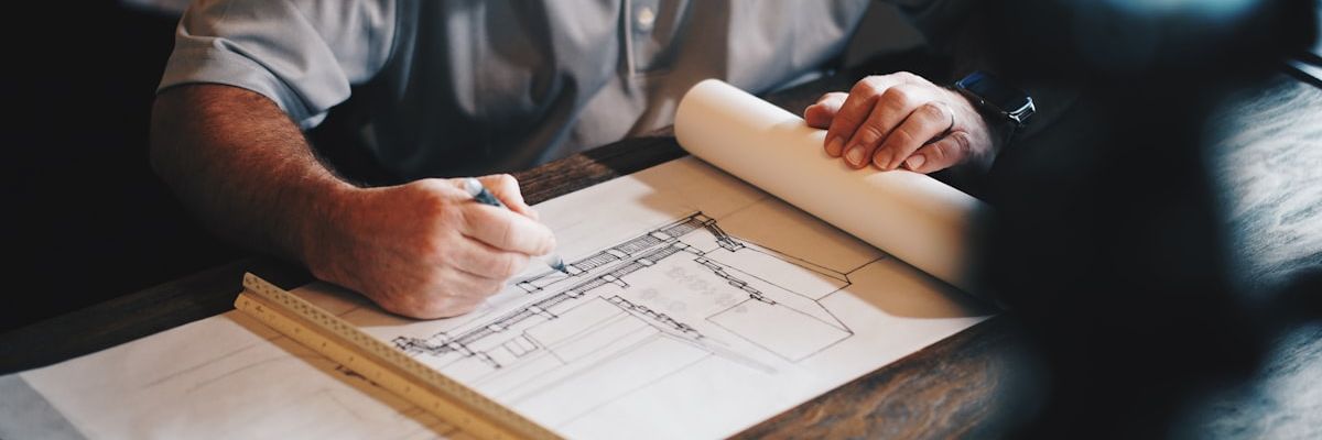 Engineering blueprints and cost estimation documents spread on a table